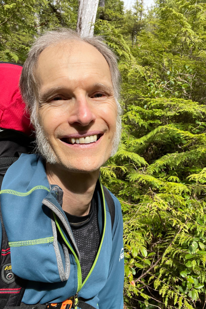 Arne Pedersen smiling with a backpack on a forest trail near Victoria, BC — symbolizing authentic confidence, mindfulness, and the personal growth journey of overcoming self-doubt through counselling and hypnotherapy.